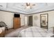 Comfortable bedroom with ceiling fan, chair, television on hutch, and entry to bathroom at 1945 Wenlok Ne Trl, Marietta, GA 30066