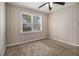 Bedroom featuring neutral carpeting, paneled walls, ceiling fan, and window with outside view at 2564 Brentwood Rd, Decatur, GA 30032