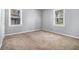 Bedroom featuring neutral carpeting, light gray walls, and windows with outside views at 2564 Brentwood Rd, Decatur, GA 30032