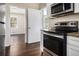 Kitchen with stainless steel oven, granite countertops, white cabinets, and wood-look flooring at 2564 Brentwood Rd, Decatur, GA 30032