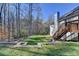 Private backyard oasis featuring a retaining wall, lush lawn, and access to a wooden deck at 4960 Markim Forest Ln, Sugar Hill, GA 30518