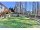 Large backyard with tiered retaining wall, lush green lawn, and privacy from mature trees, great for outdoor activities at 4960 Markim Forest Ln, Sugar Hill, GA 30518