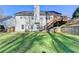 The backyard featuring tiered retaining walls, lush lawn, and outdoor entertaining space with access to the house at 4960 Markim Forest Ln, Sugar Hill, GA 30518