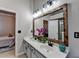 Elegant bathroom with double sinks, a rustic mirror, and modern fixtures, offering a luxurious feel at 4960 Markim Forest Ln, Sugar Hill, GA 30518