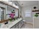 Stylish bathroom featuring double sinks, a rustic mirror, and decorative plants for a spa-like ambiance at 4960 Markim Forest Ln, Sugar Hill, GA 30518