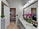 Open bathroom with double sinks, rustic mirror, and a glimpse into an adjoining bedroom at 4960 Markim Forest Ln, Sugar Hill, GA 30518