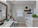 Bright bathroom with rustic mirror, neutral tile floors, and a built-in tub for ultimate relaxation at 4960 Markim Forest Ln, Sugar Hill, GA 30518
