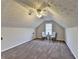 Carpeted bonus room featuring vaulted ceilings, fan, and natural light at 4960 Markim Forest Ln, Sugar Hill, GA 30518