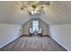 Carpeted bonus room with vaulted ceilings, fan, and natural lighting at 4960 Markim Forest Ln, Sugar Hill, GA 30518