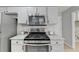 Stainless steel gas range and microwave with granite countertops and painted cabinets at 4960 Markim Forest Ln, Sugar Hill, GA 30518
