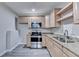 Modern kitchen with stainless steel appliances, light wood cabinets and countertops at 4960 Markim Forest Ln, Sugar Hill, GA 30518