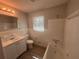 Bright bathroom with a single vanity, tub, and tiled walls for easy maintenance at 2703 Rainbow Forest Dr, Decatur, GA 30034