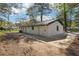 Rear view of home with clean white brick and concrete patio in private, wooded backyard at 3970 Scott Dr, Forest Park, GA 30297