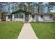 Charming single-story home with a white painted brick facade, green trim, and a well-manicured lawn at 3970 Scott Dr, Forest Park, GA 30297