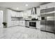 Contemporary kitchen with sleek white cabinetry, stainless steel appliances, and modern tile floors at 3970 Scott Dr, Forest Park, GA 30297