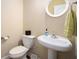 Half bathroom features a pedestal sink, round mirror, and neutral walls at 600 Jardin Ct # 48, Alpharetta, GA 30022