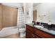 Well-lit full bathroom featuring granite countertop, shower with brown tile and shower curtain at 600 Jardin Ct # 48, Alpharetta, GA 30022