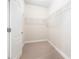 Walk-in closet with carpet flooring, open shelving, and bright white walls at 600 Jardin Ct # 48, Alpharetta, GA 30022