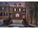 Charming brick townhome at dusk featuring a two-car garage and inviting front entrance with black iron railings at 600 Jardin Ct # 48, Alpharetta, GA 30022
