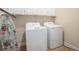 Bright laundry room with white washer and dryer, cabinets, and ironing board at 600 Jardin Ct # 48, Alpharetta, GA 30022