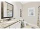 Well lit bathroom features a granite countertop, framed mirror, and neutral wall color at 7545 Rambling Vale, Cumming, GA 30028