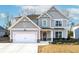 Charming two-story home with a two-car garage, landscaped yard, and classic architectural details at 7545 Rambling Vale, Cumming, GA 30028