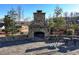 Outdoor stone fireplace with seating area, bordered by landscaping, providing a cozy community gathering spot at 7545 Rambling Vale, Cumming, GA 30028