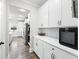 Well-organized butler's pantry with white cabinets, subway tile backsplash, and stainless steel appliances at 7545 Rambling Vale, Cumming, GA 30028
