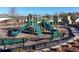 Community playground features green slides, climbing structures, and seating, with an outdoor stone fireplace nearby at 7545 Rambling Vale, Cumming, GA 30028