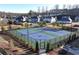 Well-maintained tennis courts are surrounded by sidewalks, trees, and other neighborhood residences at 7545 Rambling Vale, Cumming, GA 30028