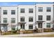 Townhomes with white brick and black window frames, featuring small landscaped yards and wrought iron fences at 310 Burgess Walk, Alpharetta, GA 30009