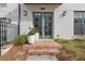 Charming home entrance featuring a light brick facade and stylish green double doors with flower planters at 310 Burgess Walk, Alpharetta, GA 30009
