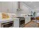 Stylish kitchen featuring stainless steel appliances, white cabinets, and an open layout to the living area at 310 Burgess Walk, Alpharetta, GA 30009