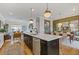 Open-concept living space with kitchen island, fireplace, and dining area at 310 Burgess Walk, Alpharetta, GA 30009