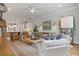 Spacious living room with an open layout, hardwood floors, fireplace, and stylish decor flowing to the kitchen at 310 Burgess Walk, Alpharetta, GA 30009
