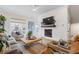 Bright and airy living room with a brick fireplace, large windows, and stylish, comfortable seating at 310 Burgess Walk, Alpharetta, GA 30009