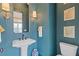 Stylish powder room with blue textured walls, pedestal sink, and modern fixtures at 310 Burgess Walk, Alpharetta, GA 30009