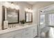 Bathroom featuring dual vanities, warm lighting, and view of the main bedroom at 520 Clover Ln, Alpharetta, GA 30009