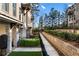 Townhome exterior with brick, manicured landscaping, and a retaining wall at 520 Clover Ln, Alpharetta, GA 30009