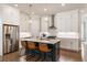 Kitchen with island and barstool seating, stainless steel appliances, pendant lighting, and white cabinetry at 520 Clover Ln, Alpharetta, GA 30009