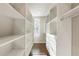A walk-in closet with hardwood floors is equipped with custom white shelving and drawers at 520 Clover Ln, Alpharetta, GA 30009