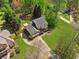 Bird's-eye view of a home with a well manicured lawn, an extended driveway, and mature trees, under a sunny sky at 5815 P.W.A. Dr, Cumming, GA 30041