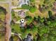 An overhead shot displays a well maintained suburban home surrounded by mature trees and lush green lawns at 5815 P.W.A. Dr, Cumming, GA 30041