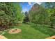 Lush backyard featuring mature trees and manicured lawn with a fire pit feature at 5815 P.W.A. Dr, Cumming, GA 30041