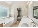 Bright bathroom features double sinks, vanity, a soaking tub by a frosted window and tile flooring at 5815 P.W.A. Dr, Cumming, GA 30041