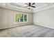 Spacious bedroom with tray ceiling, large window, and plush carpeting at 5815 P.W.A. Dr, Cumming, GA 30041