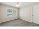 Carpeted bedroom features a ceiling fan and a window offering natural light at 5815 P.W.A. Dr, Cumming, GA 30041