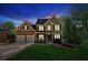 Charming two-story home featuring a manicured lawn, brick accents, a two-car garage, and traditional architectural details at 5815 P.W.A. Dr, Cumming, GA 30041