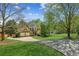 Traditional home with a long driveway and large front yard surrounded by mature trees under a sunny blue sky at 5815 P.W.A. Dr, Cumming, GA 30041