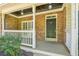 Close-up view of a cozy front porch with stone detailing, a classic black door, and a neat white railing at 5815 P.W.A. Dr, Cumming, GA 30041